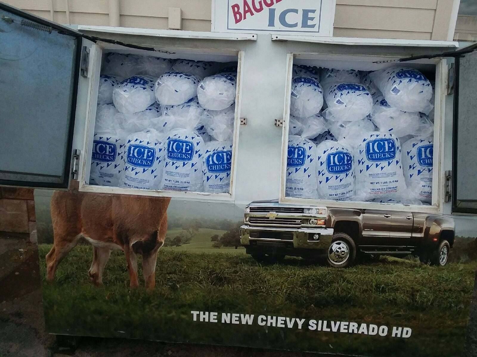 Ice vending machine with bags of ice. Ad for a Chevy Silverado below, with a deer in a field.