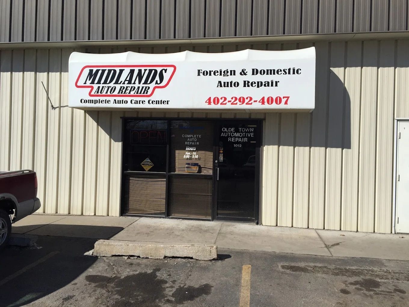 Midlands Auto Repair storefront with sign, beige metal building, and glass entrance