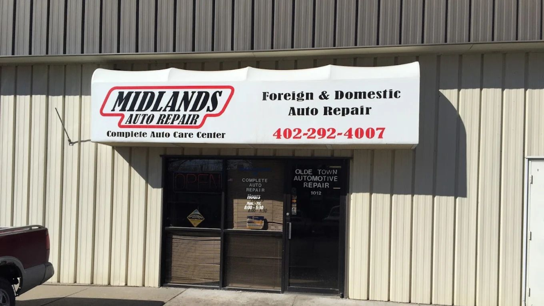 Midlands Truck Repair storefront with white sign, beige metal siding, and glass entrance doors