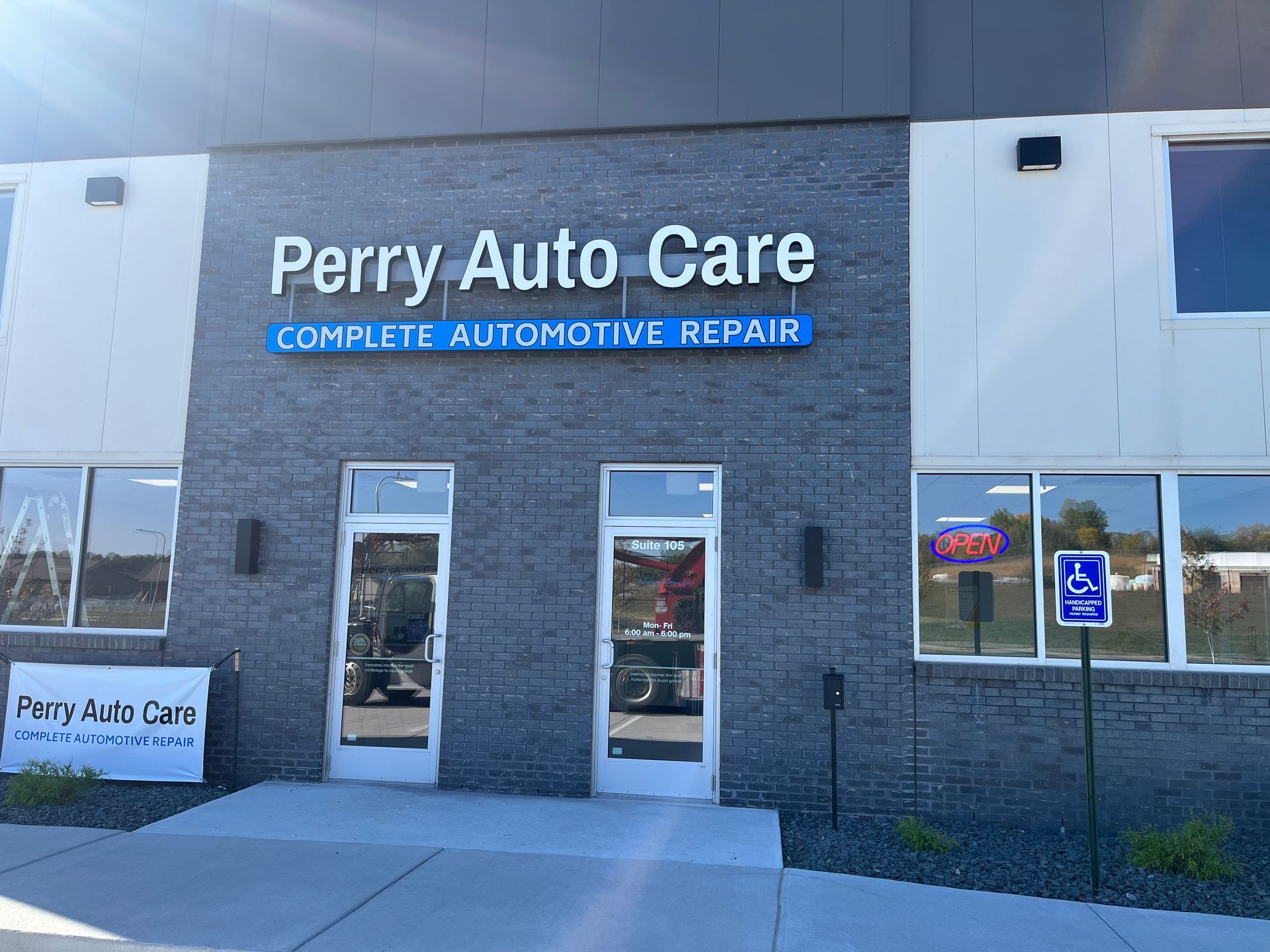Perry Auto Care storefront with blue sign and entrance doors in a commercial building