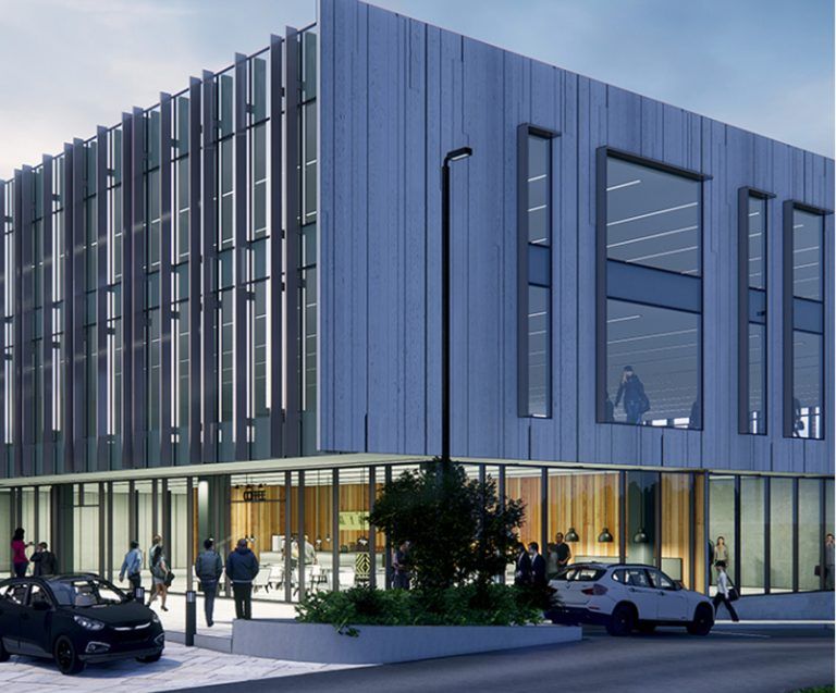 Modern office building with glass facade, people entering, cars parked in front.