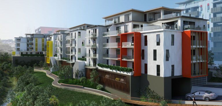 Modern apartment complex with white and orange facade, built on a hillside.