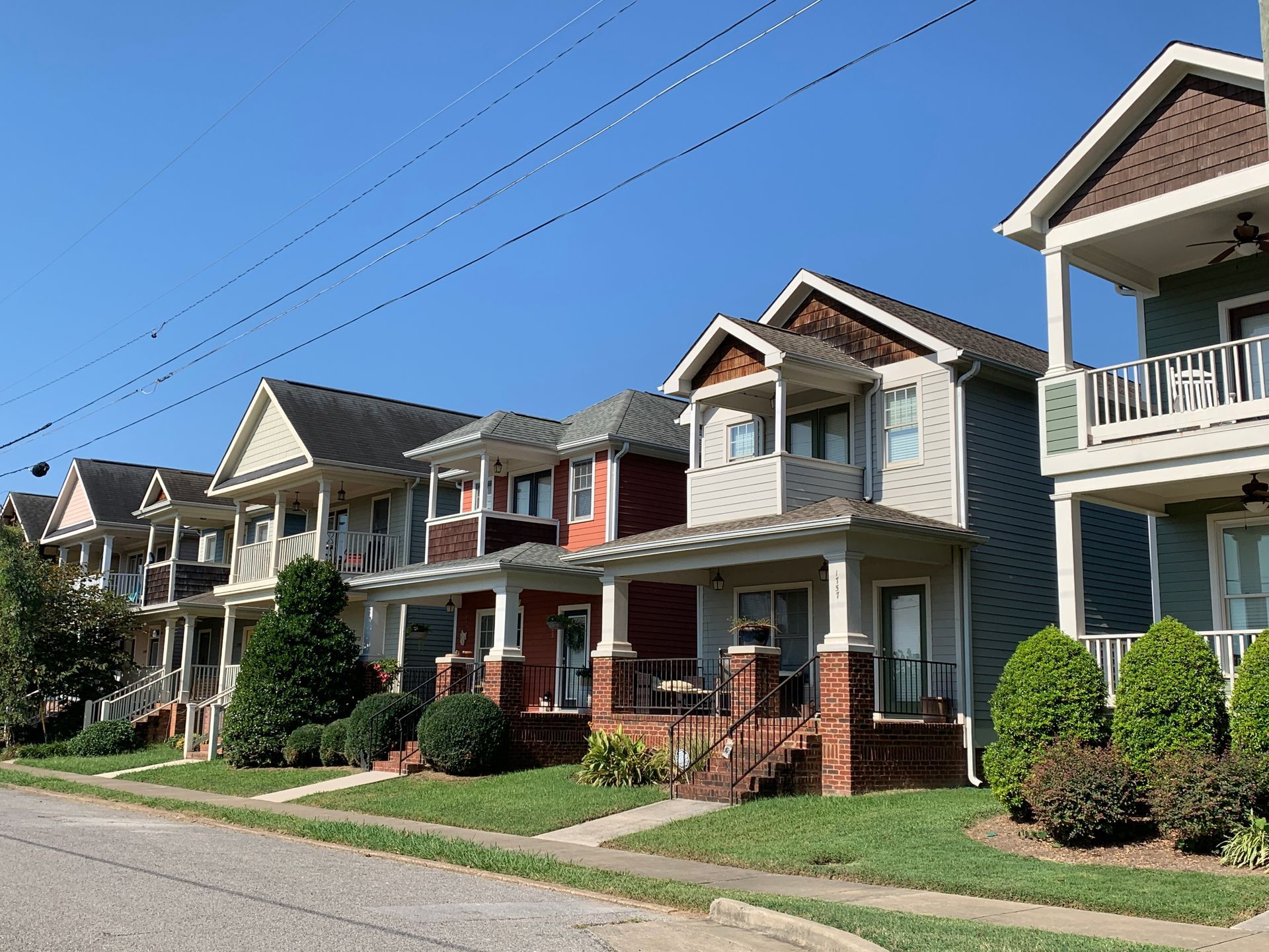 Row of colorful houses with porches on a sunny day.