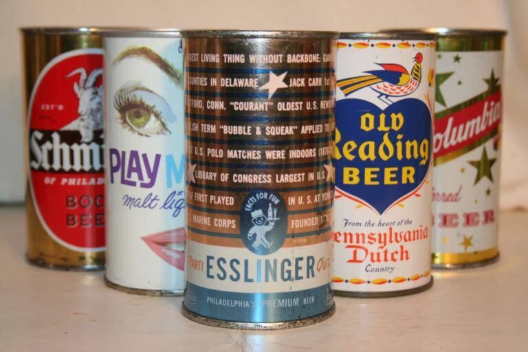 Assorted vintage beer cans arranged in a row on a table, featuring colorful labels and logos