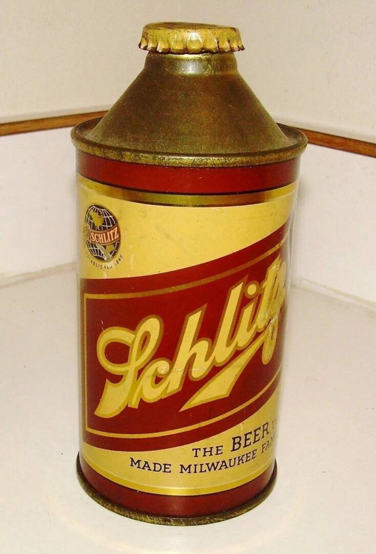 Vintage Schlitz beer can in yellow and red with gold top, standing on a countertop