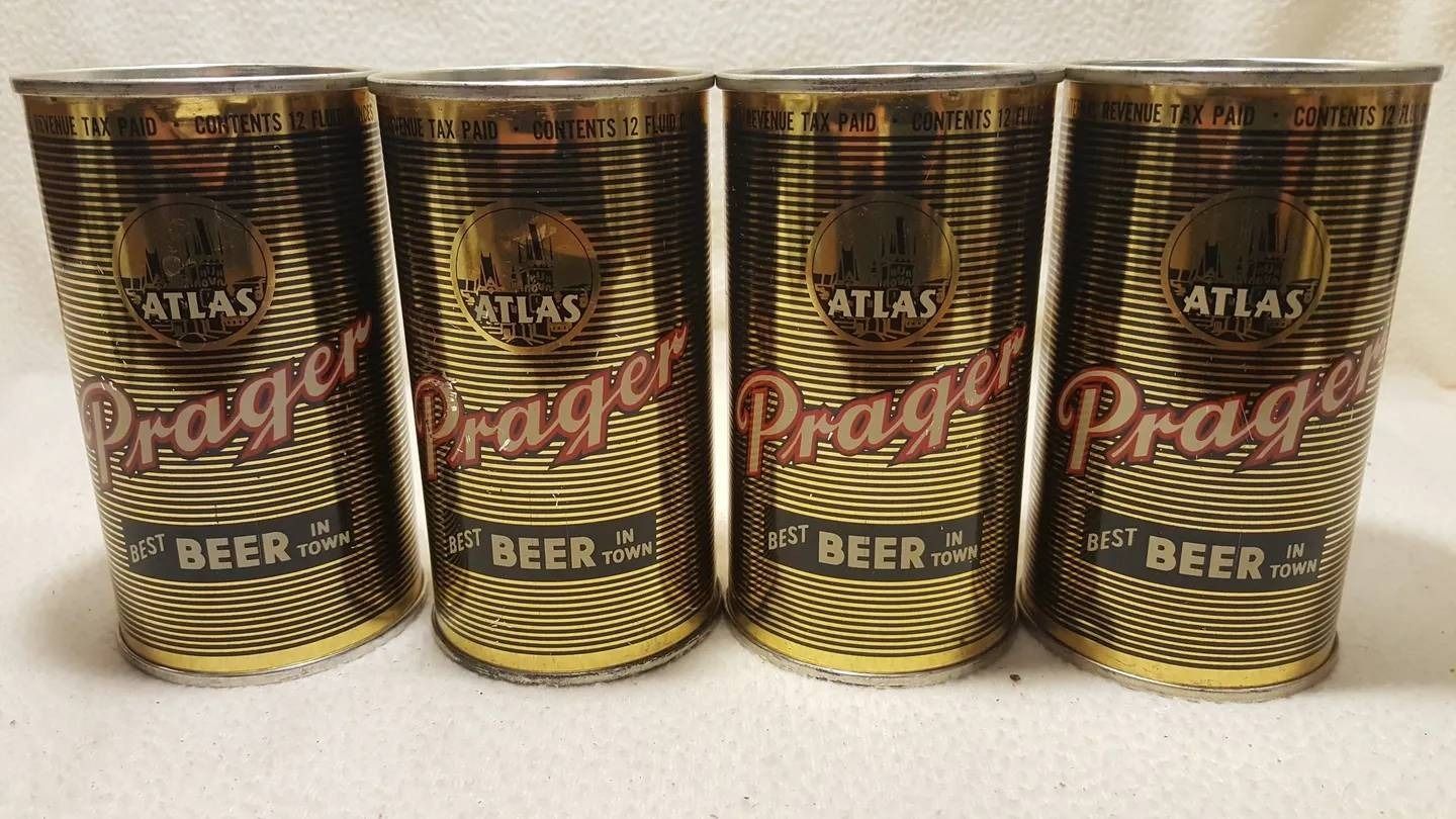 Four Atlas Prague beer cans standing in a row on a white background