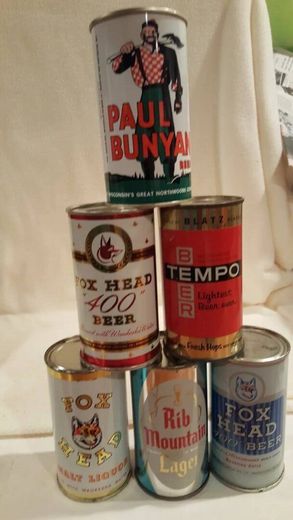 Stack of vintage beer cans, including Paul Bunyan, Tempo, and Rib Mountain Lager, arranged in a pyramid