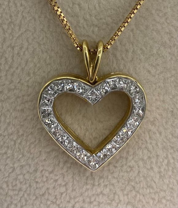 Gold heart pendant necklace with princess-cut diamonds around the edge.