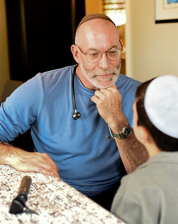 Dr. Michael Milobsky, pediatrician at Chicken Soup Concierge Pediatrics visits with a child