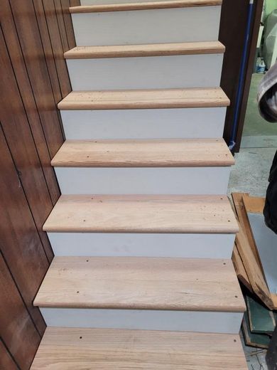 Wooden staircase with white risers and light wood treads.