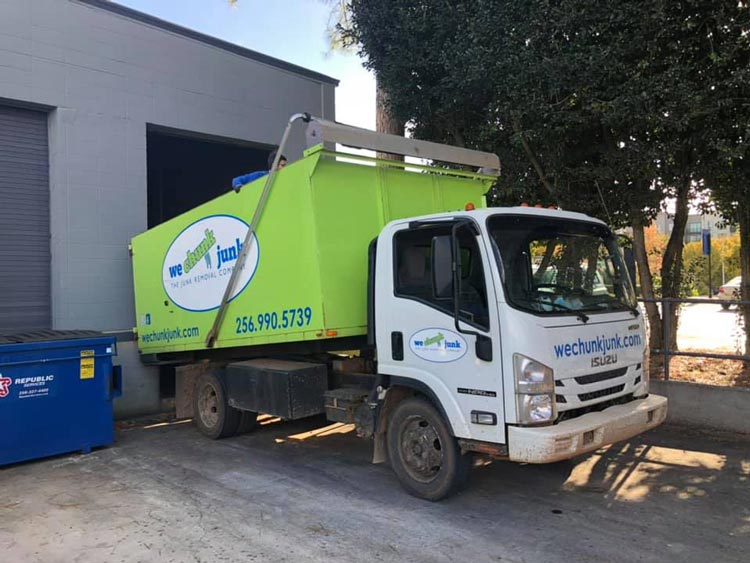 A garbage truck is parked in front of a building.