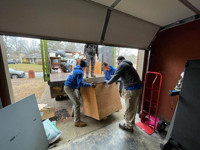A group of people are moving a large piece of wood into a garage.