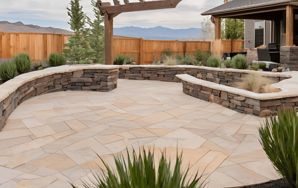 Stone patio with low stone walls, wooden pergola, and view of mountains.