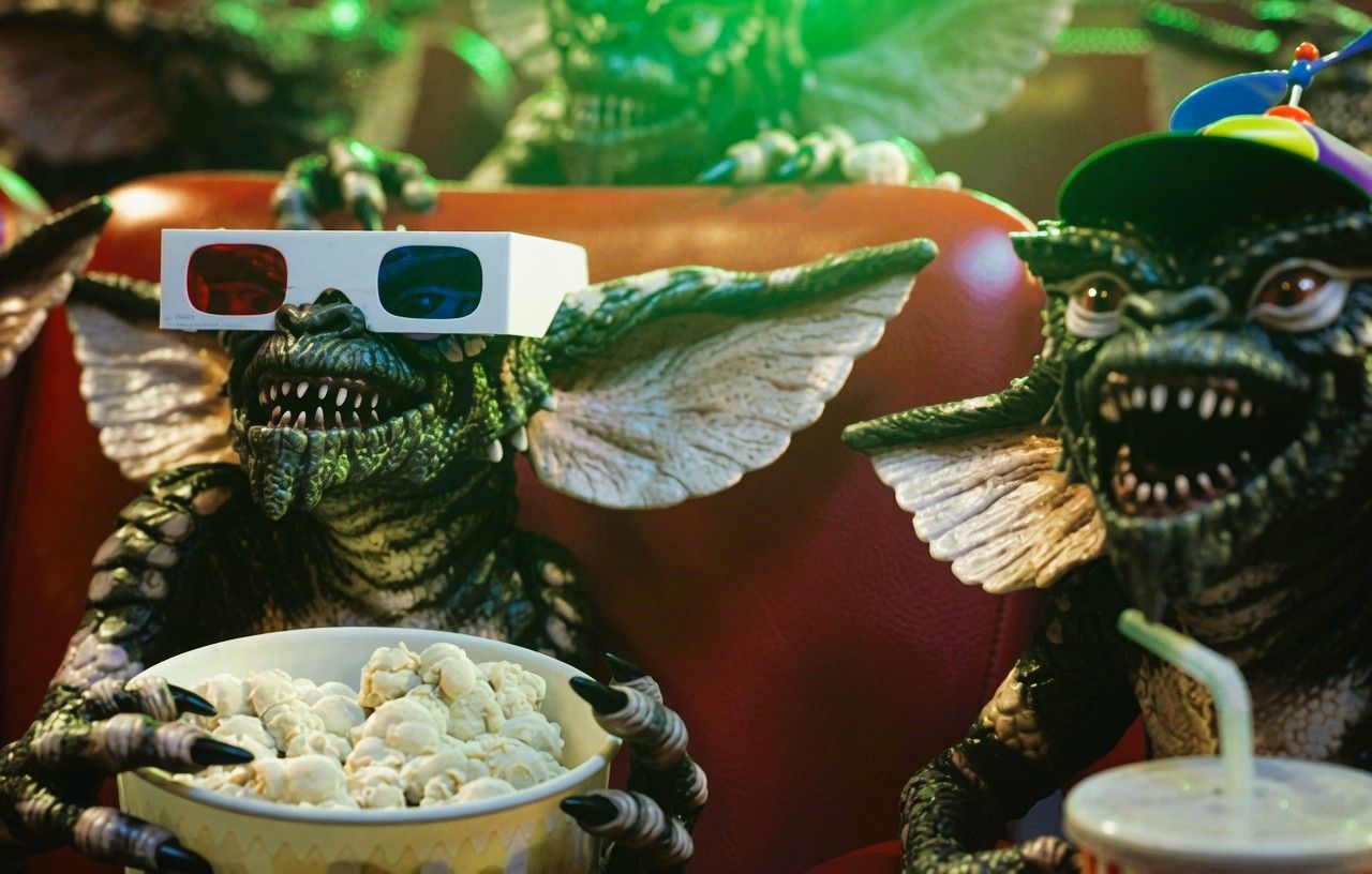 Gremlins enjoying popcorn at the cinema as excitement builds for Gremlins 3 following its official announcement.