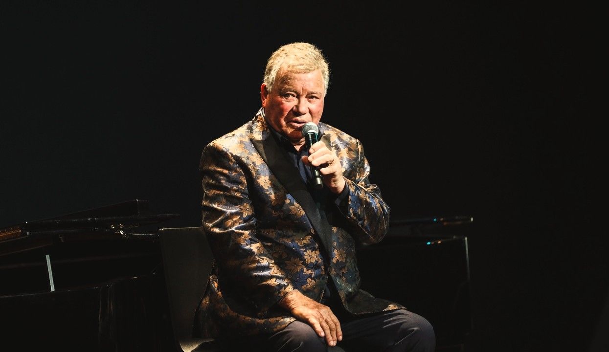 William Shatner performing live on stage during one of his musical appearances.