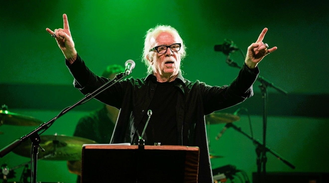 John Carpenter performing live on stage and making the metal horns gesture