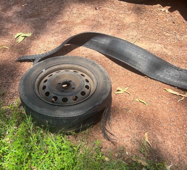 Flat Tire on Dirt With a Long Piece of Black Material — Mudpig Mechanical In Humpty Doo, NT