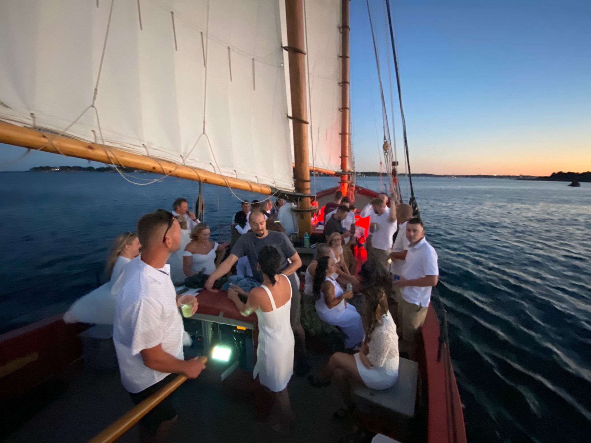 A group of young people are having a party on a schooner in Salem Harbor.