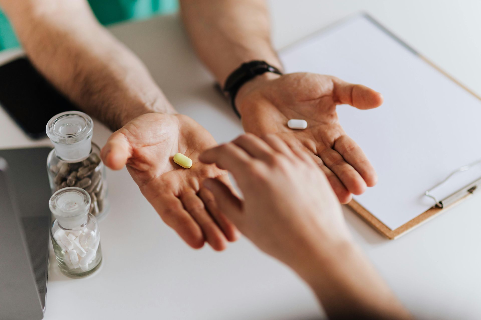 A doctor is giving a patient a pill in his hand.