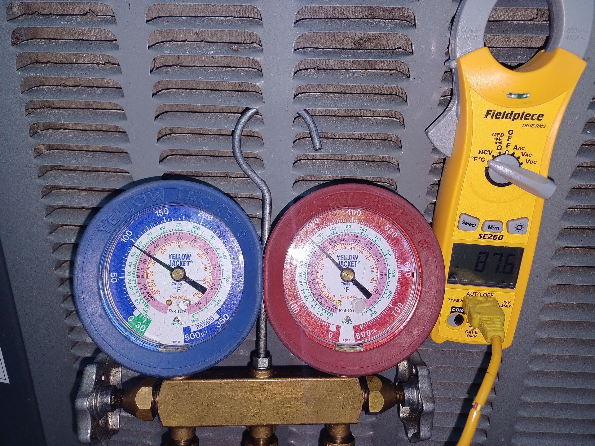 HVAC refrigerant gauges showing pressure readings during AC service by Arnett Mechanical