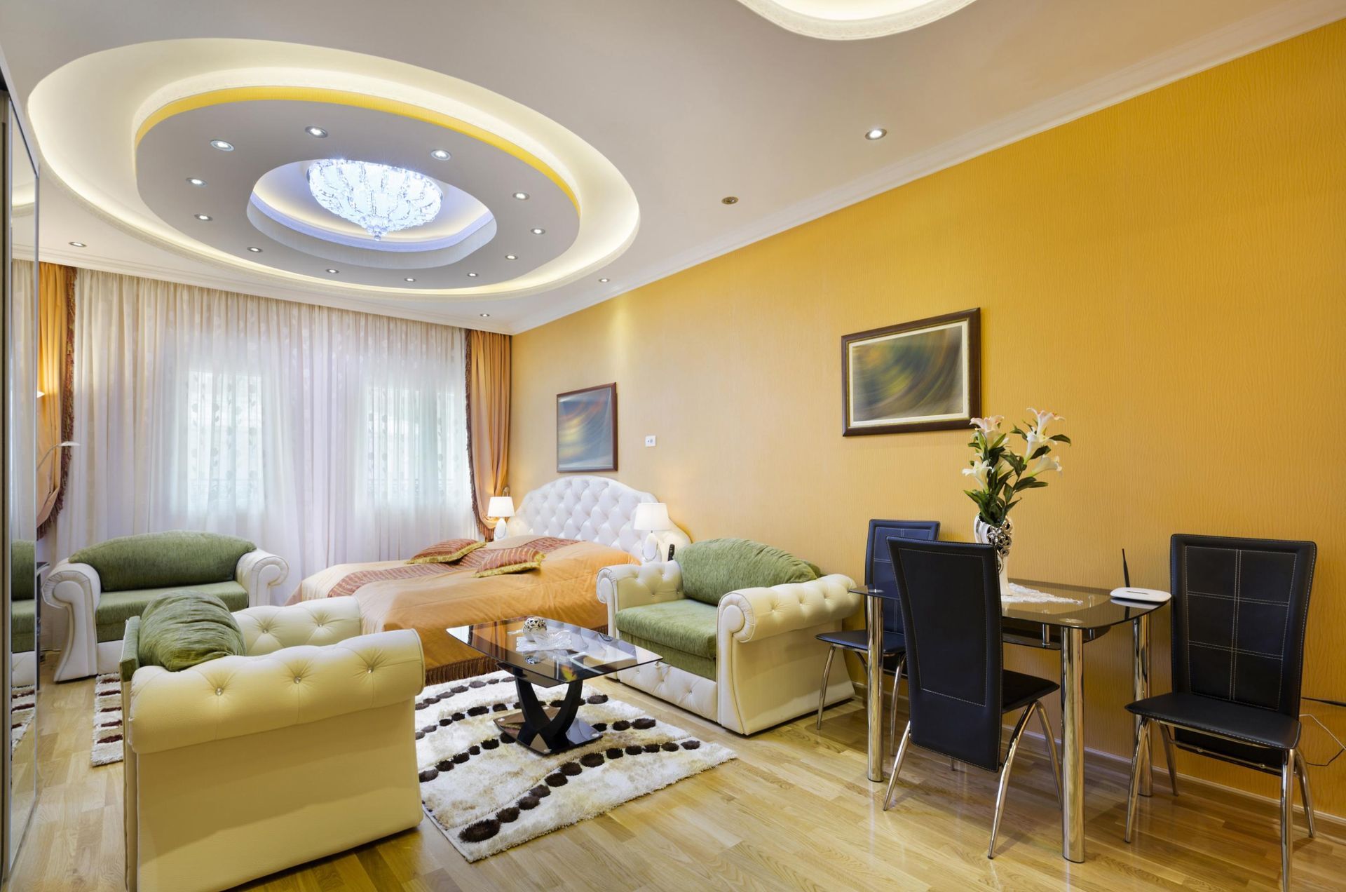 Elegant living room with yellow walls, cream sofas, glass dining table, and circular ceiling lights