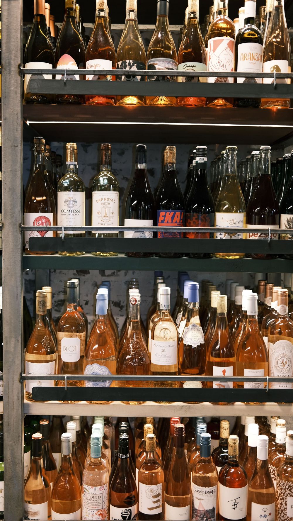 A shelf filled with lots of bottles of wine.