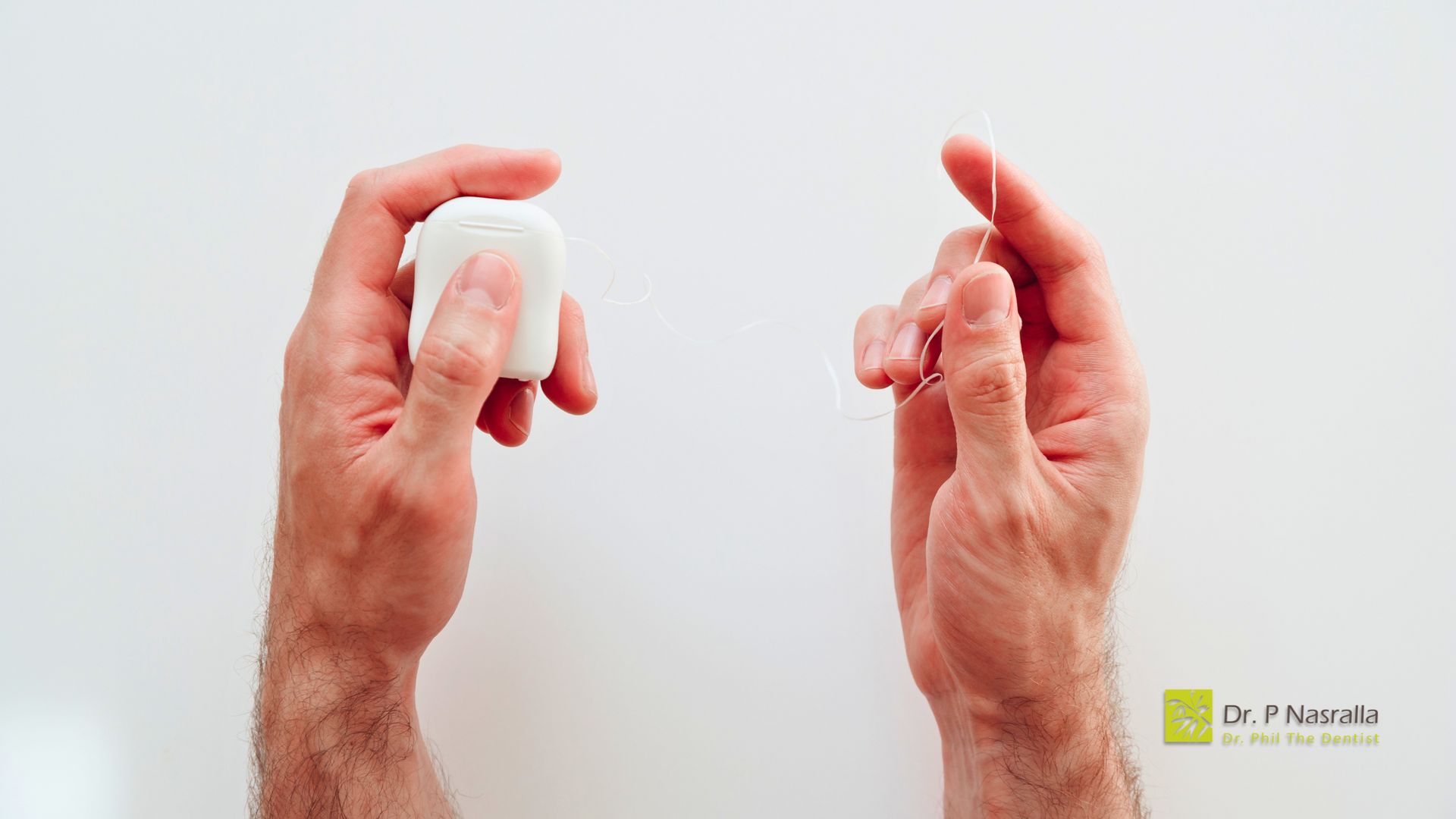 A man is holding a toothbrush and a toothpick in his hands.
