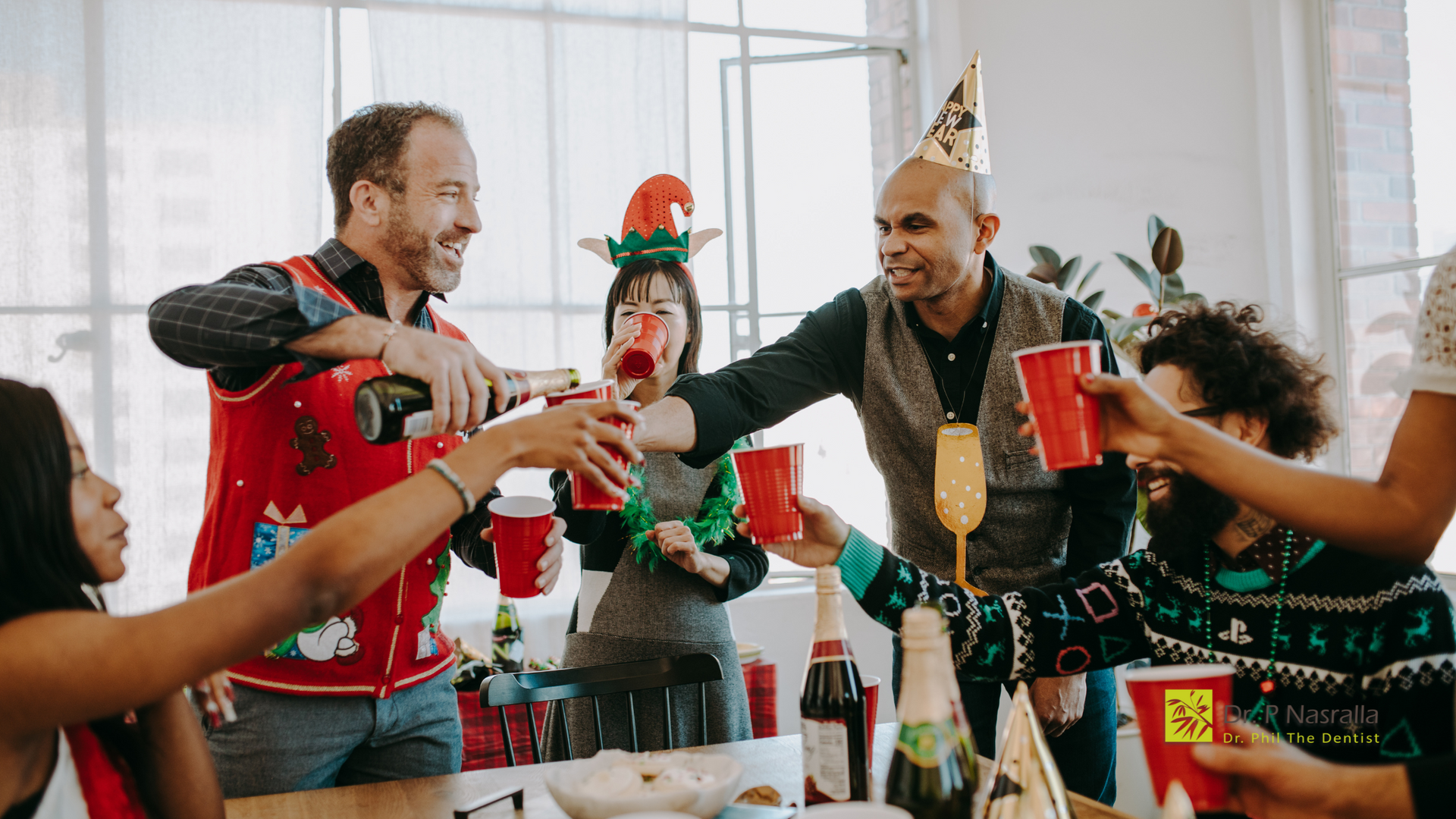 A group of people are sitting around a table at a christmas party.