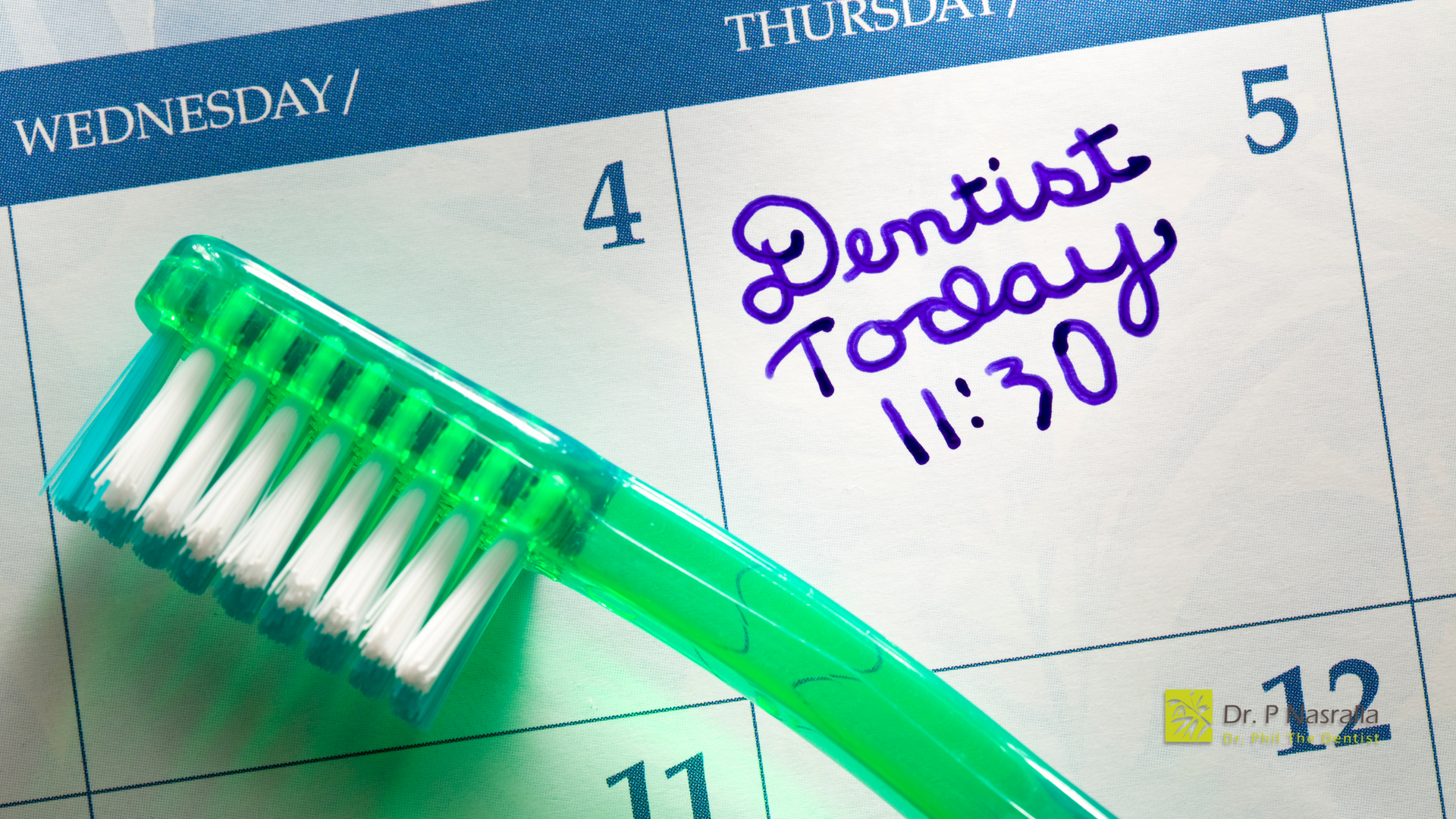 A green toothbrush is sitting on top of a calendar that says dentist today