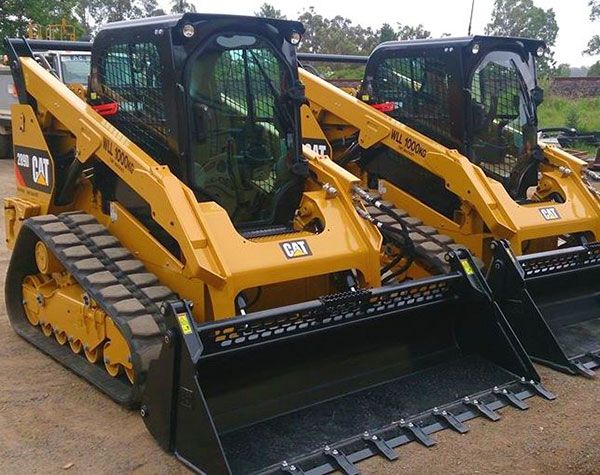 Two caterpillar tractors are parked next to each other