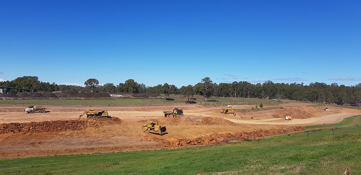 A large dirt field with a lot of machinery in it.