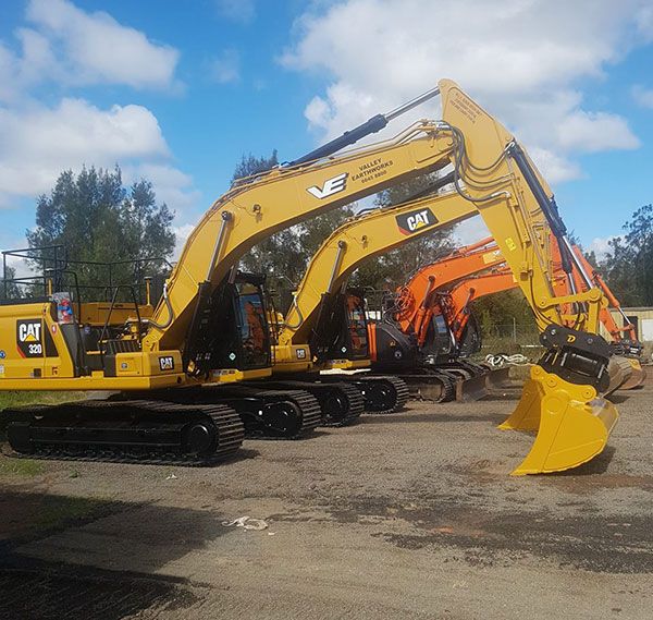 A row of yellow excavators with cat written on the side