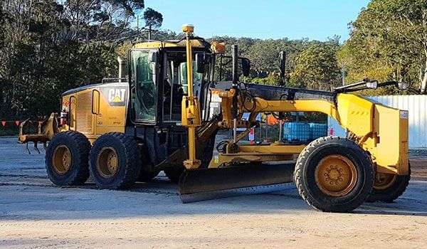 A large yellow bulldozer is parked in a parking lot.