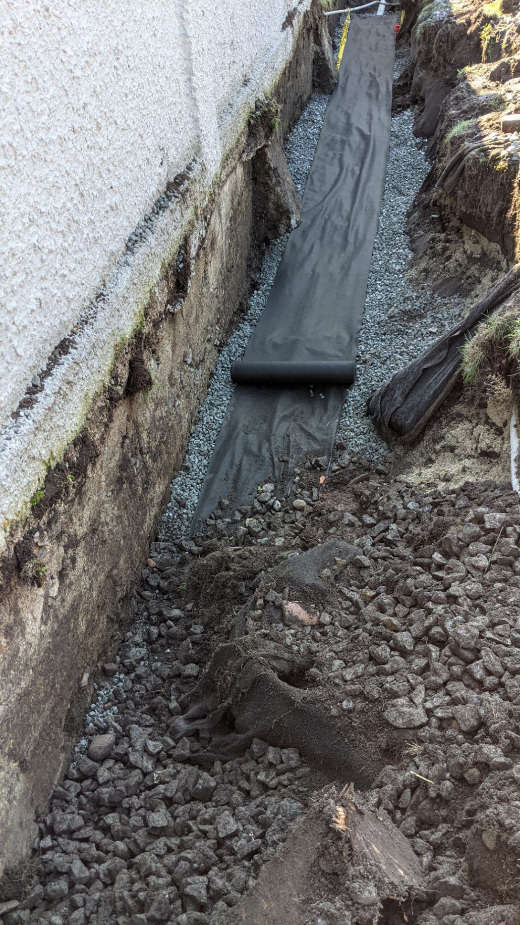 Drain cloth laid down on drain rock as part of a new perimeter drain system for residential home