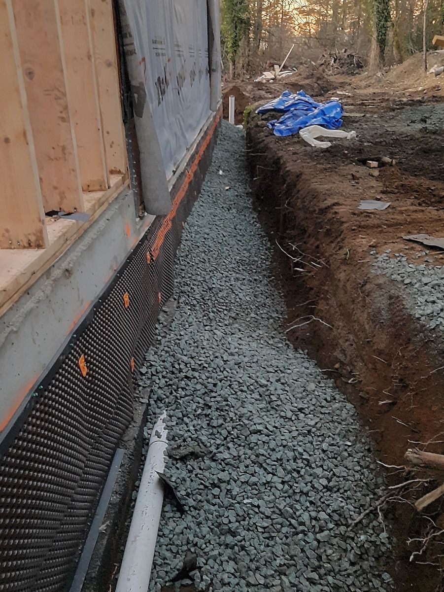 Drain rock laid over fresh line of PVC drain pipe