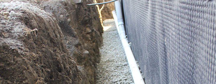 New foundation drainage system in trench with drain rock