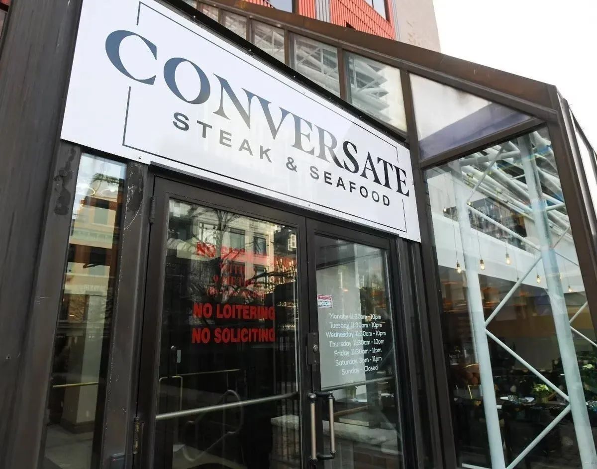 Sign for Conversate Steak & Seafood restaurant. Glass enclosed entrance with 