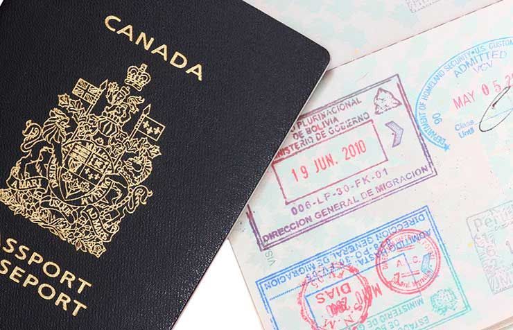 A close up of a canadian passport and a passport with stamps