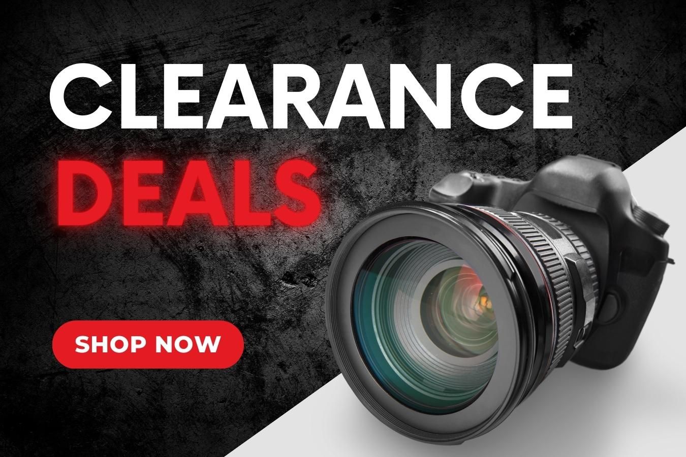 A camera is sitting on a table next to a sign that says clearance deals.