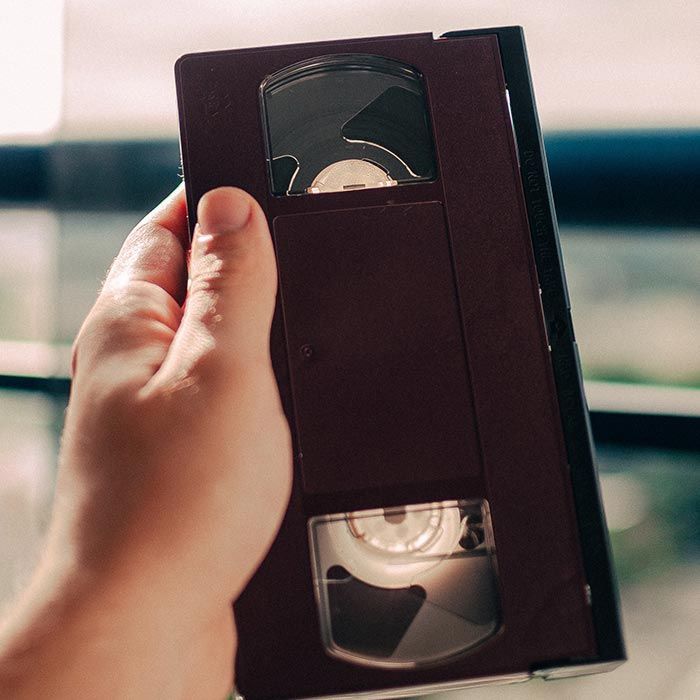 A person is holding a vhs tape in their hand