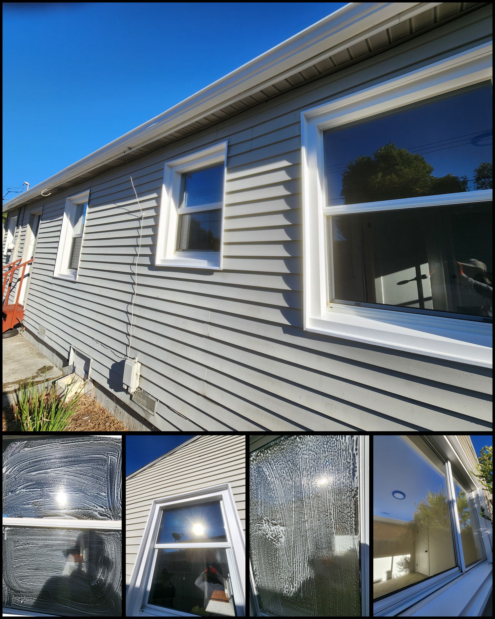 Gray vinyl-sided house exterior with white-trim windows and reflective windows on a sunny day