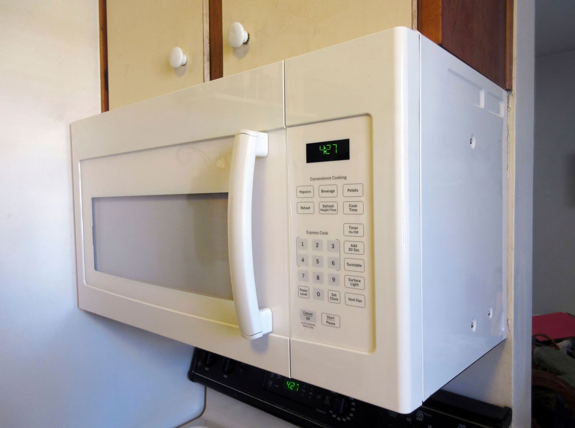 A white microwave is sitting on top of a kitchen counter.