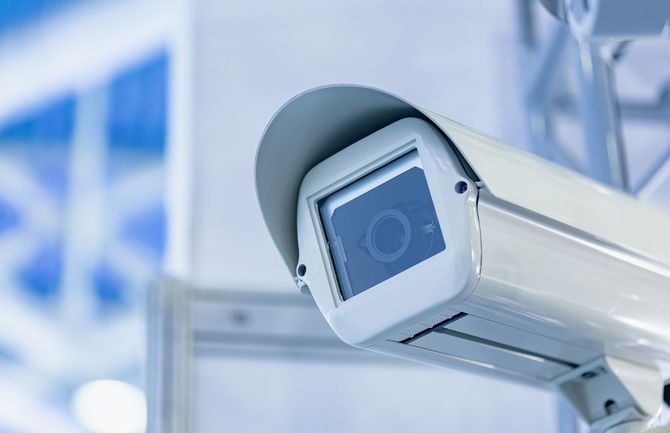 Security camera in a bright indoor setting, angled toward the viewer
