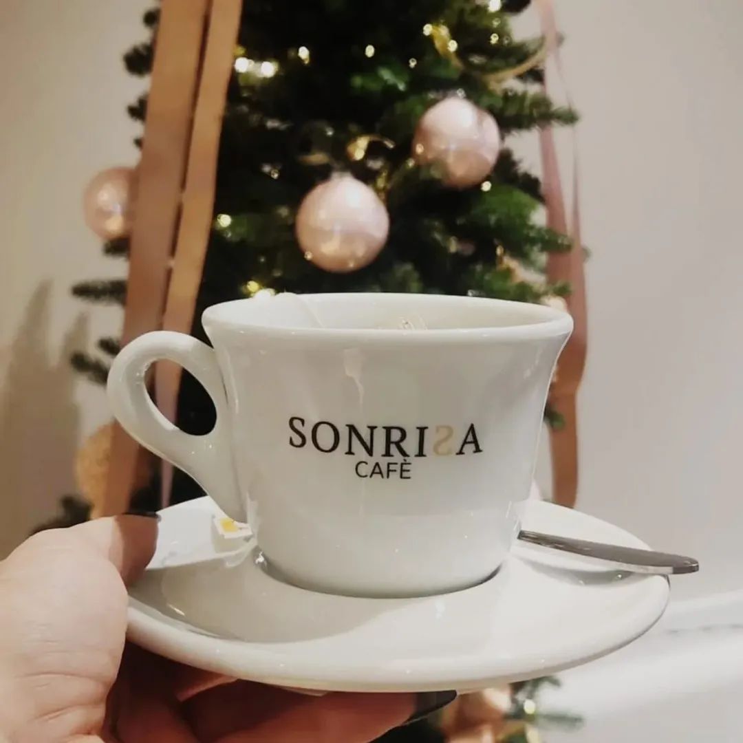 Mano che tiene una tazza di caffè bianca