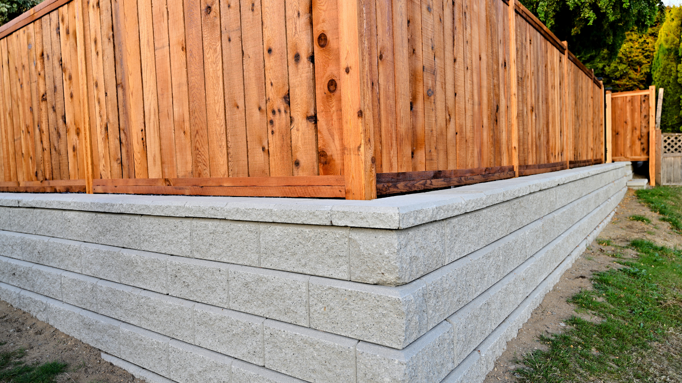 A wooden fence is surrounded by a concrete wall.