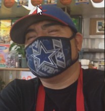 A man wearing a mask that says cowboys on it