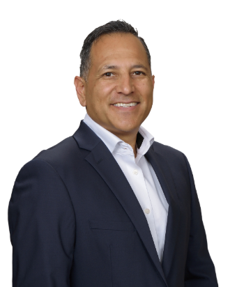A man in a suit and white shirt is smiling for the camera.