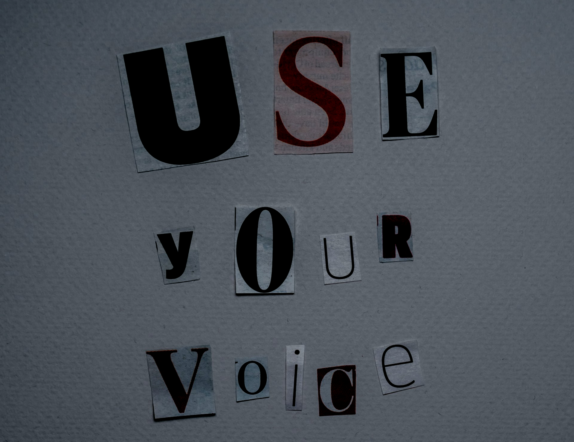 A sign that says use your voice cut out of newspaper