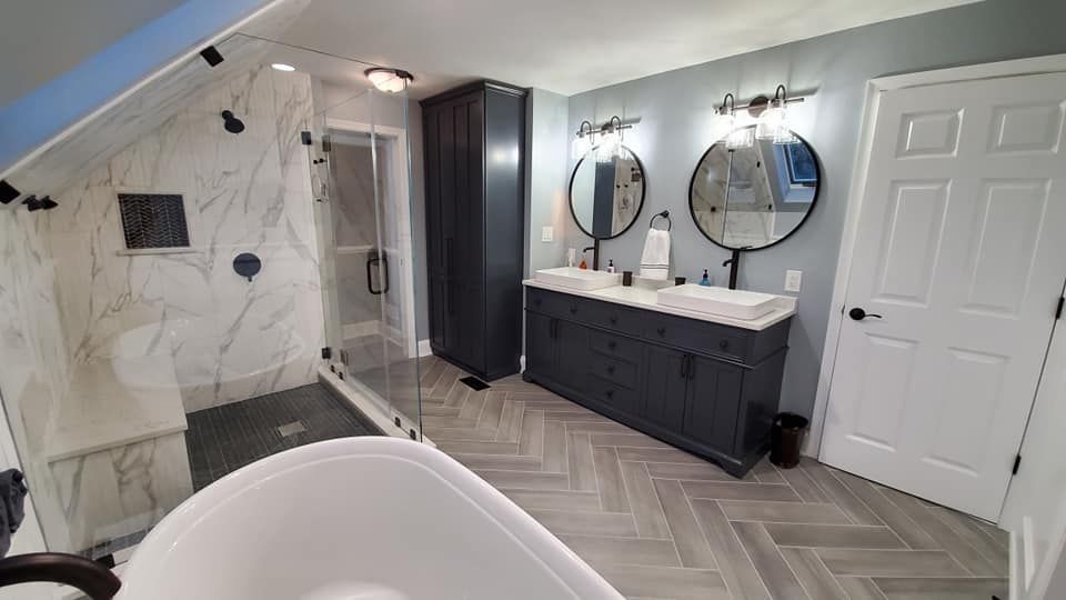 A bathroom with two sinks , a walk in shower , and a bathtub.