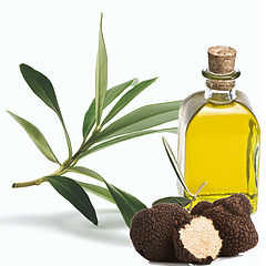 Glass bottle of yellow essential oil with green leaves and truffle mushrooms on a white background